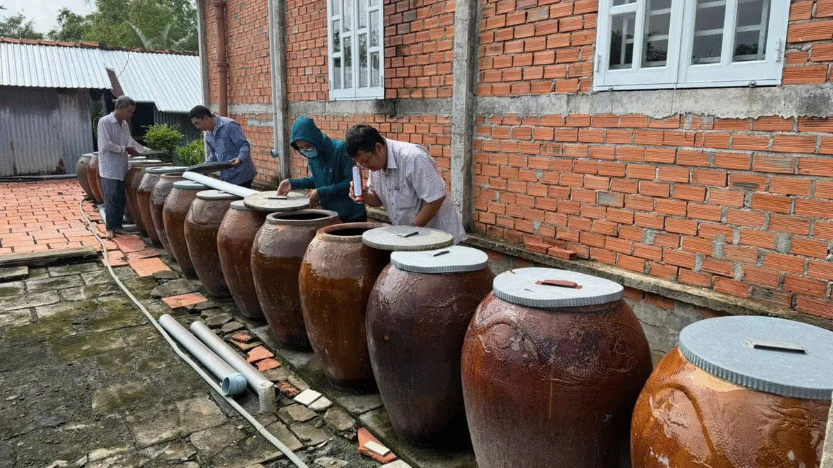 Cán bộ kiểm tra chum, vại chứa nước của hộ gia đình, ảnh tiêu biểu bài PLOS NTDs